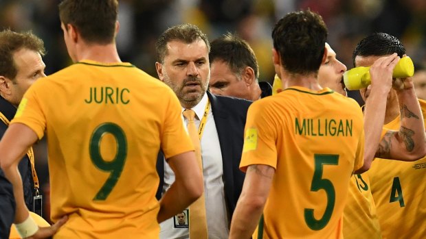 Home delivery: Socceroos coach Ange Postecoglou with his charges at the extra-time break on their way to victory over Syria.