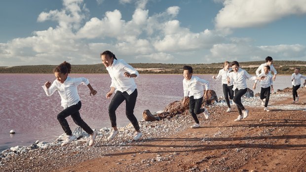 The Qantas Choir pictured running next to WA's bubblegum pink Hutt Lagoon.