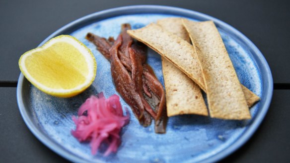 Ortiz anchovies with house-pickled onions, a lemon cheek and crostini.