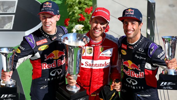Sebastian Vettel celebrates on the podium next to Daniel Ricciardo (right) and Daniil Kvyat of Russia.