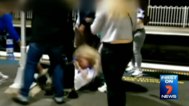 A woman, who was attacked on the platform, being kicked in the head.