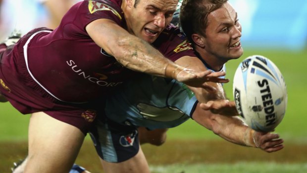 Cameron Smith of the Maroons and Matt Moylan of the Blues fight for the ball.