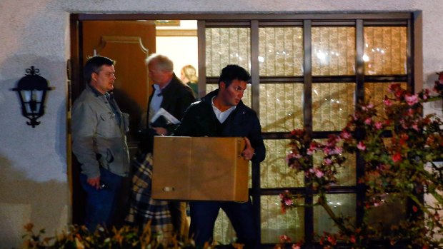 German police officers carry boxes out of a house believed to belong to the parents of crashed Germanwings flight 4U 9524 co-pilot Andreas Lubitz.