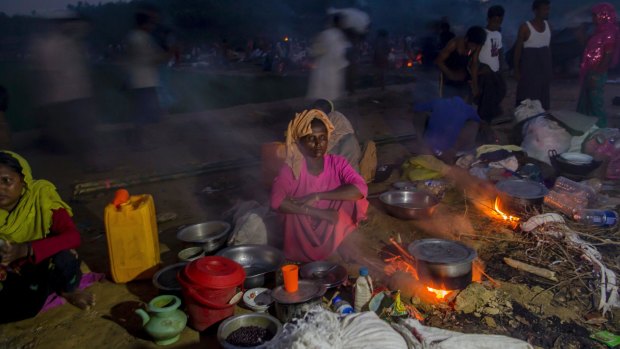 Rohingya Muslims, who crossed over from Myanmar into Bangladesh, prepare a meal in the open at Taiy Khali refugee camp, in Bangladesh.