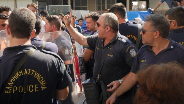 Greek riot police try to keep some order inside the stadium in Kos on Thursday.