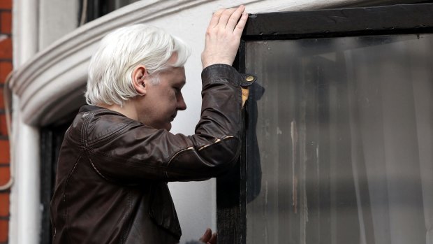 Julian Assange makes his way back indoors after speaking to the media.