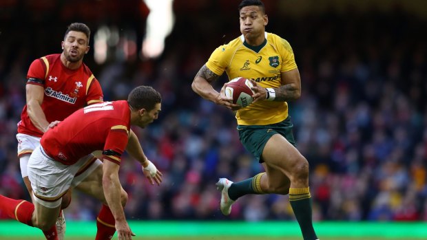 Too quick: Israel Folau of Australia escapes the tackle from George North of Wales.