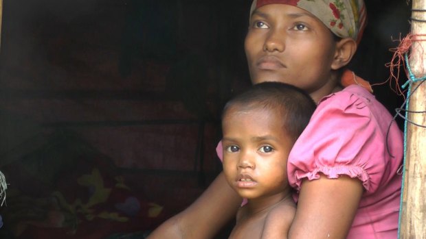 Four-year-old Rosmaida Bibi, who suffers from severe malnutrition, with her mother Hamida Begum's lap. She cannot grow and they cannot leave their refugee camp to find help. 