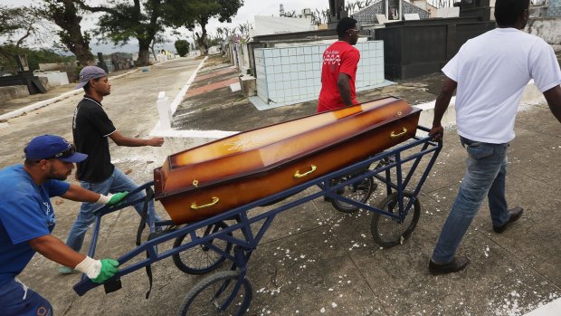 Leonardo Martins da Silva helps move the casket during the burial of his son Leonardo.