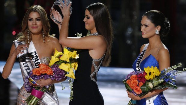 Former Miss Universe Paulina Vega, centre, removes the crown from Miss Colombia Ariadna Gutierrez, left, before giving it to Miss Philippines Pia Alonzo Wurtzbach, right.