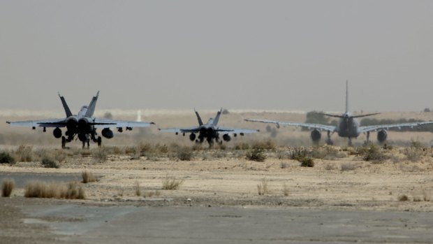 Two RAAF Super Hornets following a Multi-Role tanker transport along a taxiway to commence a mission in Iraq.