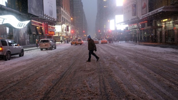Deserted: A man crosses Times Square in New York during the blizzard.