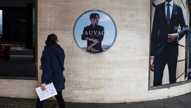 Commuters walk past the Dior Sauvage advertisement featuring Johnny Depp outside David Jones' Sydney CBD store.