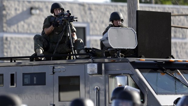 A police tactical team moves in to disperse  protesters in Ferguson, Missouri, in August 2014.