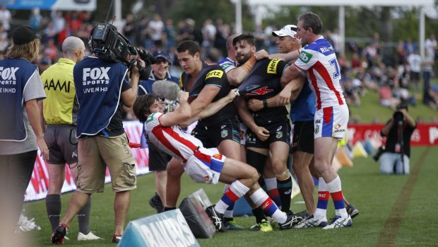 Boiling over: The tussle spills over the sideline.