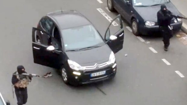 A frame grab taken from footage posted by Jordi Mir shows hooded gunmen aiming rifles towards a police officer.