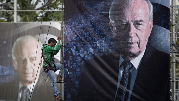 An Israeli worker hangs up a billboard with a portrait of late Israeli Prime Minister Yitzhak Rabin, ahead of the memorial rally.