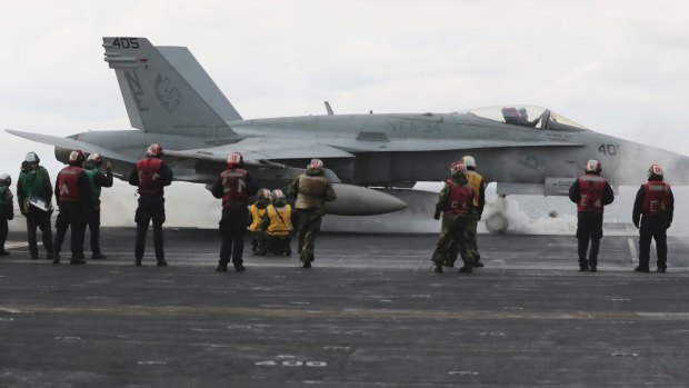 An F/A-18 fighter prepares to take off from the deck of the aircraft carrier USS Carl Vinson at an unidentified location in international waters east of the Korean Peninsula.