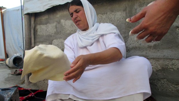 A Yazidi refugee makes dough at a camp in northern Iraq.