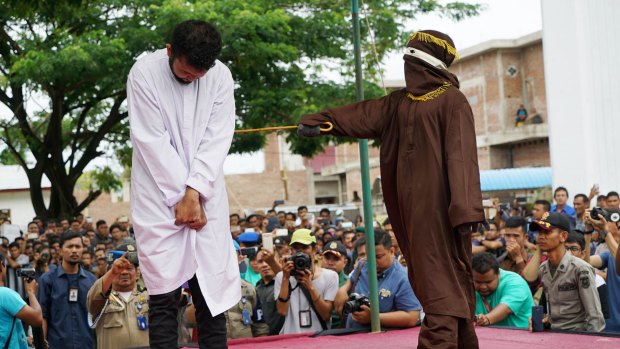 A man is whipped in public for violating sharia law in relation to homosexuality in Banda Aceh, Indonesia.