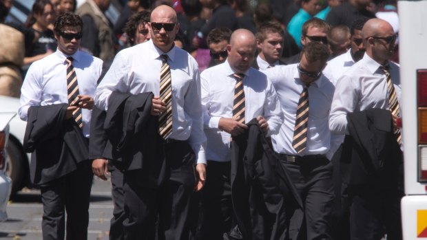 Dark day: West Tigers players go towards their bus after the funeral of Mosese Fotuaika.