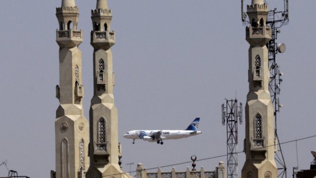 An EgyptAir plane flies past minarets of a mosque as it approaches Cairo International Airport.
