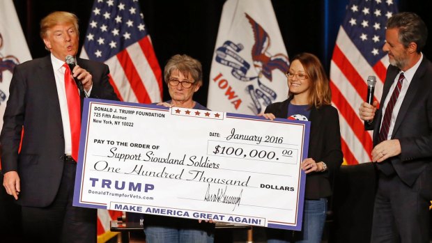 Donald Trump  presents a cheque to members of Support Siouxland Soldiers in January.