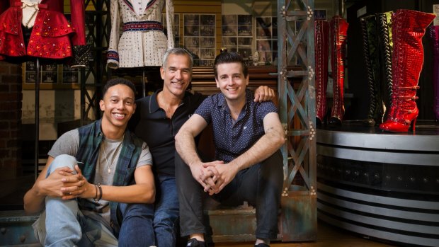 Director Jerry Mitchell (centre) with actors Callum Francis and Toby Francis, and some of the sparkling costumes from <i>Kinky Boots</i>.
