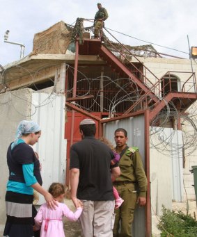 Israeli soldiers help settlers move into a house on the outskirts of Hebron in the Israeli-occupied West Bank on April 13.