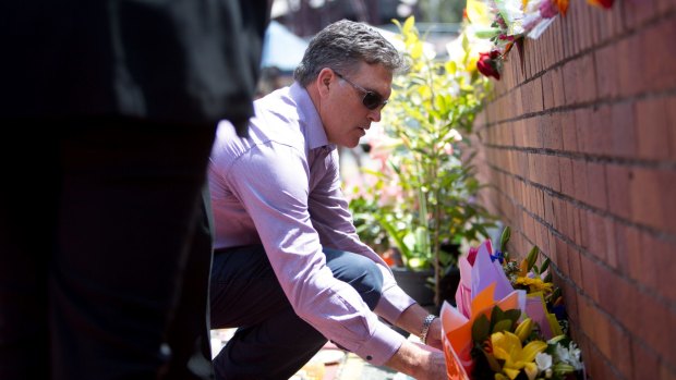 Dreamworld chief executive Craig Davidson leaves flowers at the theme park on Friday.
