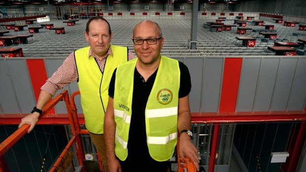 Irresistible bargains: Catch Group head of logistics Jon Northope (left) and founder Gabby Leibovich on a cherry picker overseeing the company's $20 million investment in warehouse robots (pictured behind) to help sort and pack bargains.