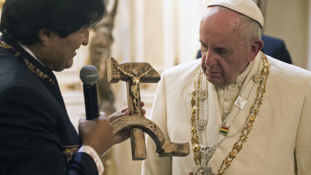 Pope Francis is presented a gift of a crucifix carved into a wooden hammer and sickle, the Communist symbol uniting labour and peasants, by Bolivian President Evo Morales in La Paz, Bolivia.