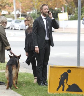 Justin Hemmes and his dog at Paul Ramsay's funeral.