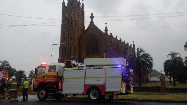 Firefighters extinguish the fire at the St Marys Catholic Church in Warwick, struck by lightning in this week's storm.