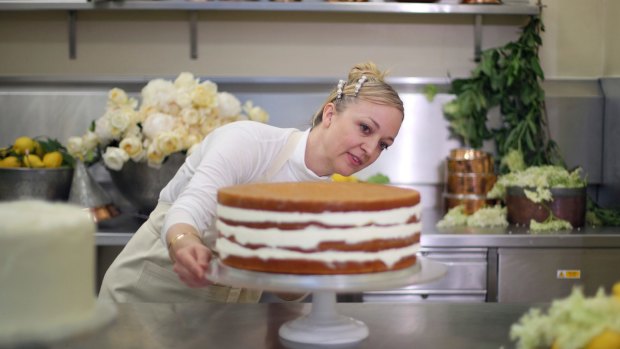 Claire Ptak, owner of Violet Bakery puts the finishing touches to one tier of the cake.