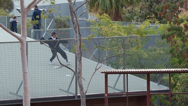 One of the youths throwing an object at the approaching police. 