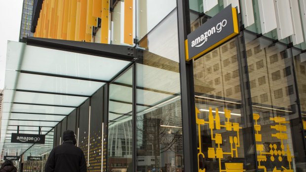 Pedestrians walk past the new Amazon.com grocery store in Seattle, Washington.