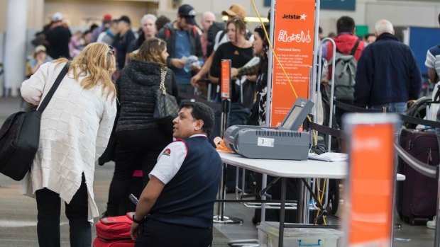 Passengers queue at Sydney airport on Sunday.