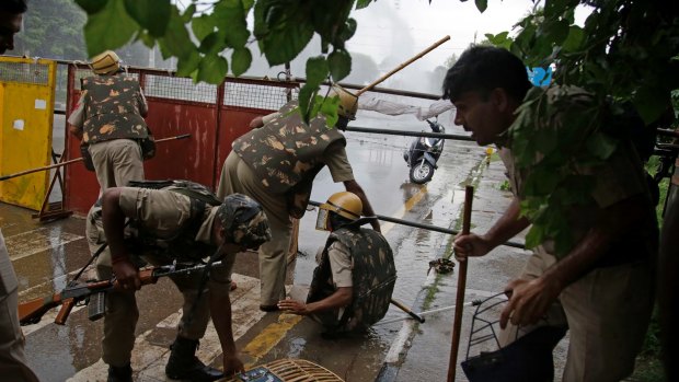 Indian policemen retreat after being attacked by Dera Sacha Sauda sect members in Panchkula, India.