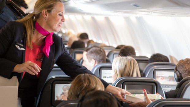 A flight attendant serves passengers on board Wednesday's zero waste flight from Sydney to Adelaide.