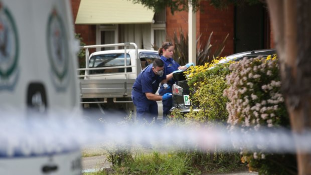 Police and forensic investigators survey the scene following the death in Panania.