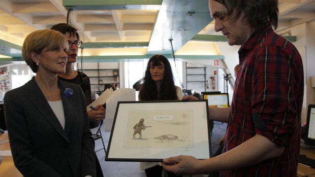 Foreign Affairs Minister Julie Bishop with the famous cartoon at the temporary offices of <i>Charlie Hebdo</i>.