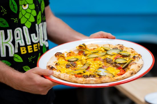 Cheeseburger pizza topped with San Marzano tomatoes, American cheese, red onion, beef mince, pickles and mustard.