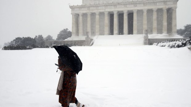 Jasmine Wang walks through snow in front of the Lincoln Memorial in Washington.