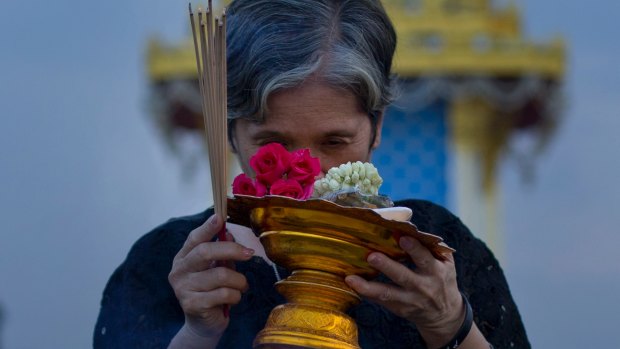 A Thai mourner prays in front of a replica of the royal crematorium in Bangkok.