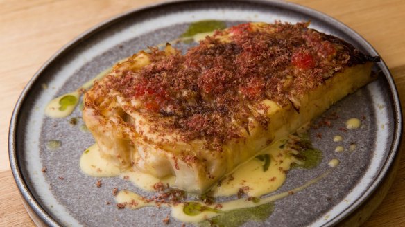 A slab of cabbage topped with shaved dried ox heart.