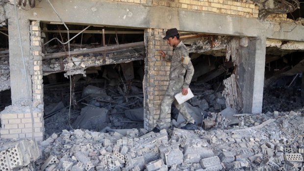A soldier inspects the demolished tomb of former Iraqi president, Saddam Hussein in Tikrit, Iraq.