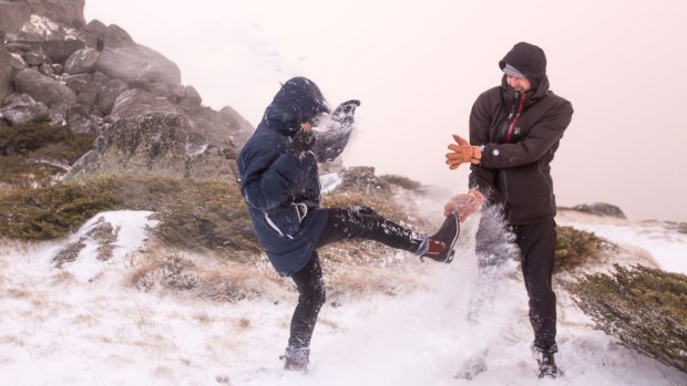 Tiggy Cameron and Luke Kneller have some fun after the first snow at Thredbo on May 11.
