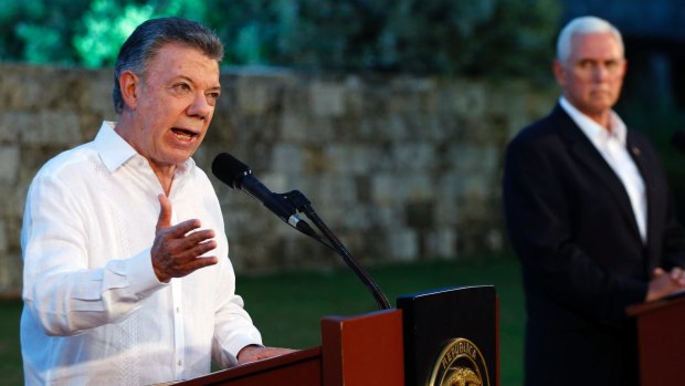 Colombia's President Juan Manuel Santos, left, talks to the media as US Vice-President Mike Pence listens.
