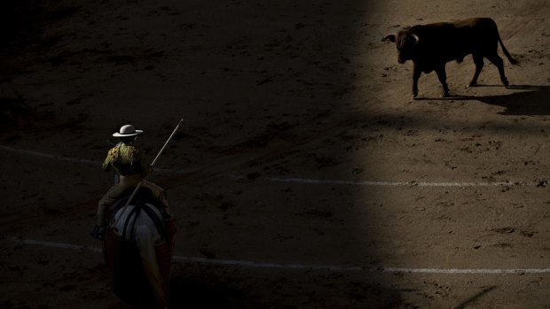 A bullfighter "picador" prepares to use his lance as he rides his horse in front of a Los Rodeos ranch's bull during a bullfight at Las Ventas bullring in Madrid, Spain.